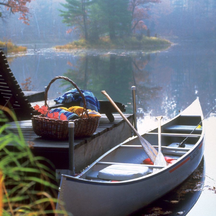 A canoe along with equipment sitting by a dock at Canoe Bay.
