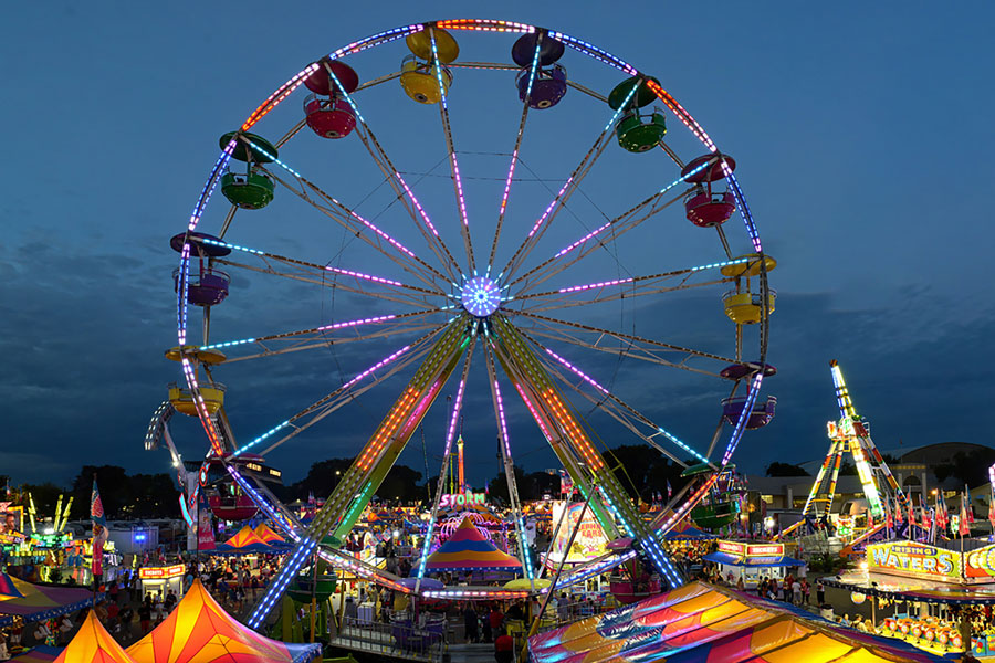 A picture of the ferris wheel and other Midway rides at night at the Minnesota State Fair.