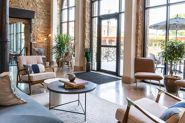 Hotel lobby with exposed stone walls and modern furniture at Lora Hotel in Stillwater