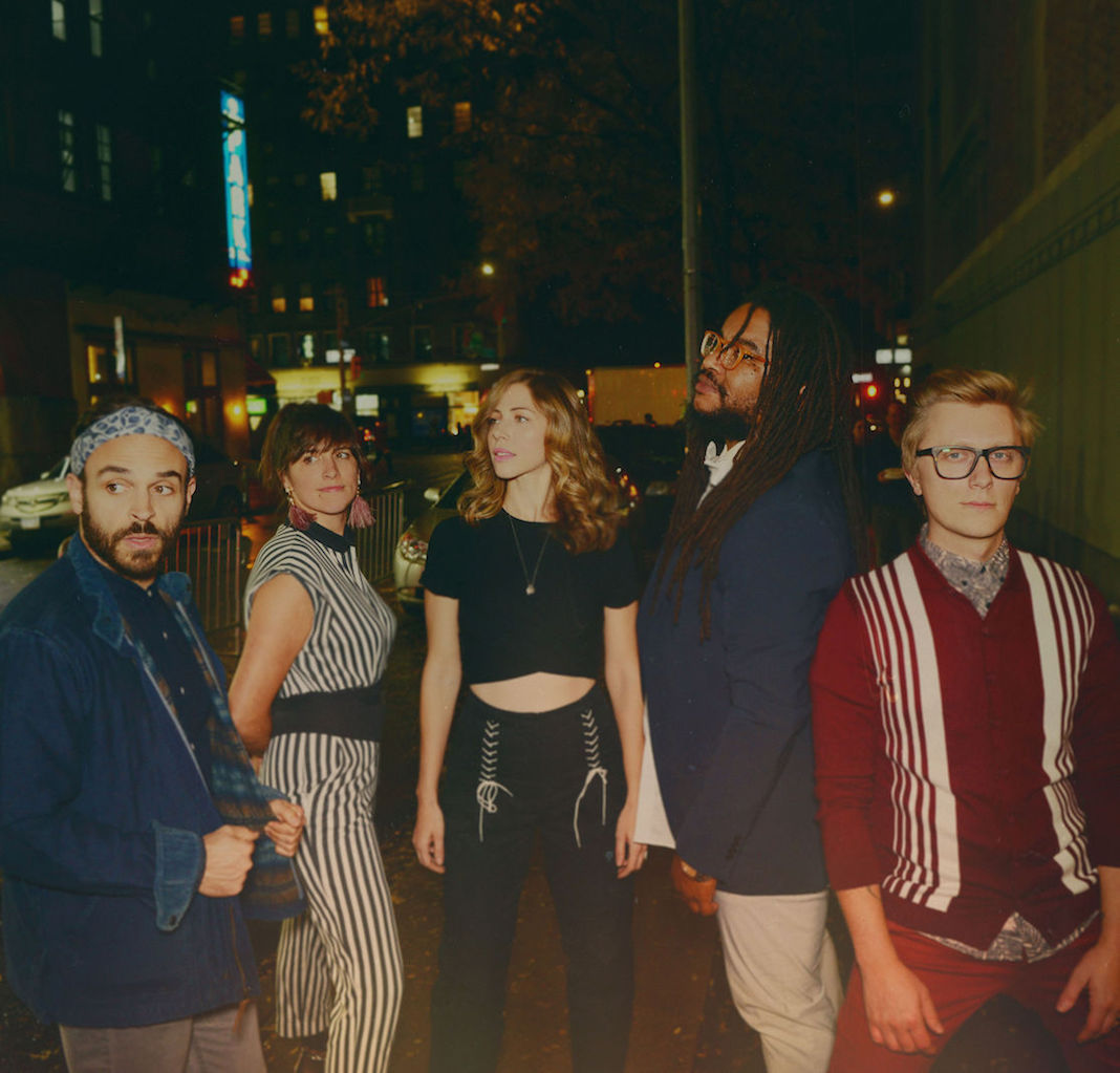 Mike Calabrese, Bridget Kearney, Rachel Price, Akie Bermiss, and Mike Olson — the members of Lake Street Dive — pose outside in a city at night