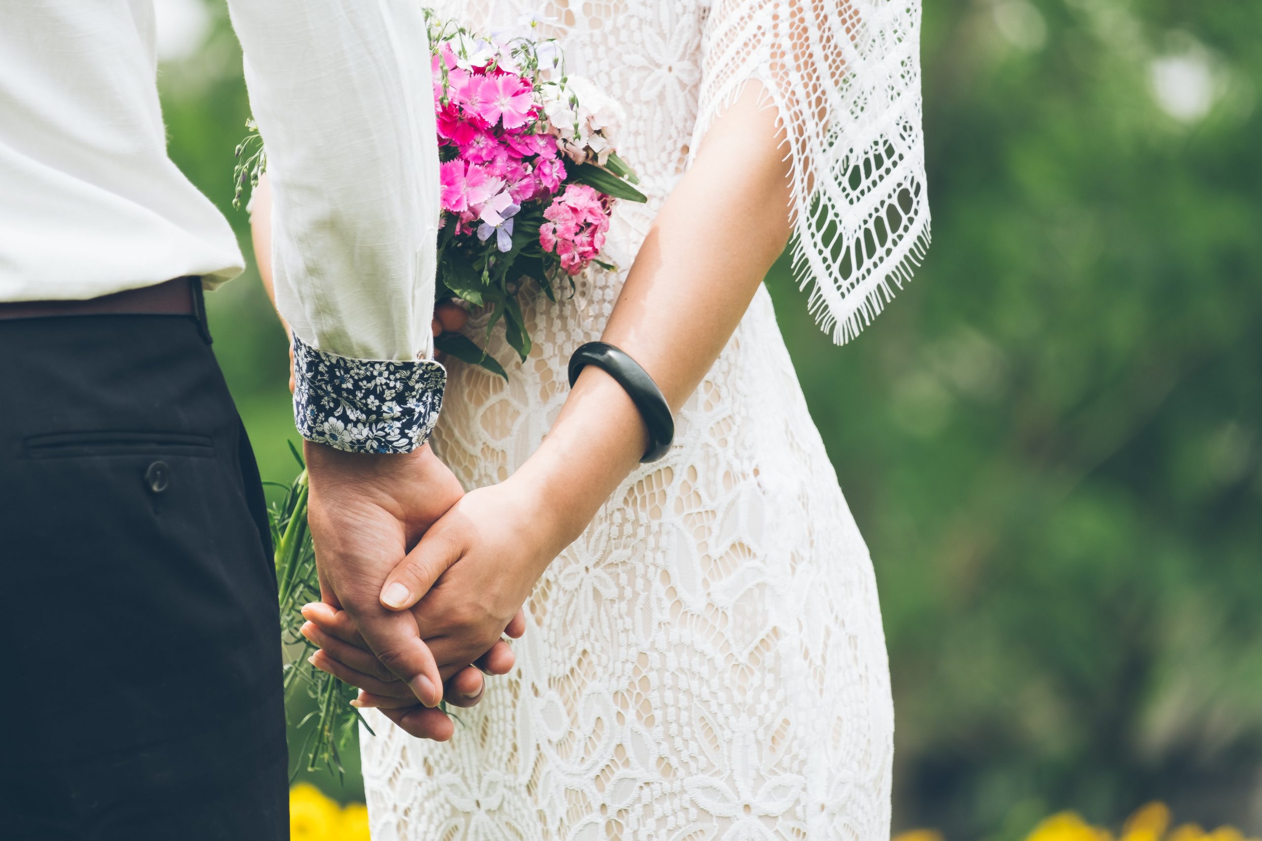 A wedding couple outside in the spring, holding hands.