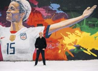 wes burdine stands near a mural painted on the exterior of black hart of St. Paul